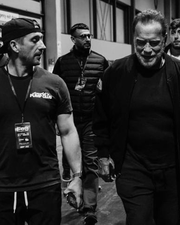 Daniel Ketchell walking with Arnold Schwarzenegger backstage
